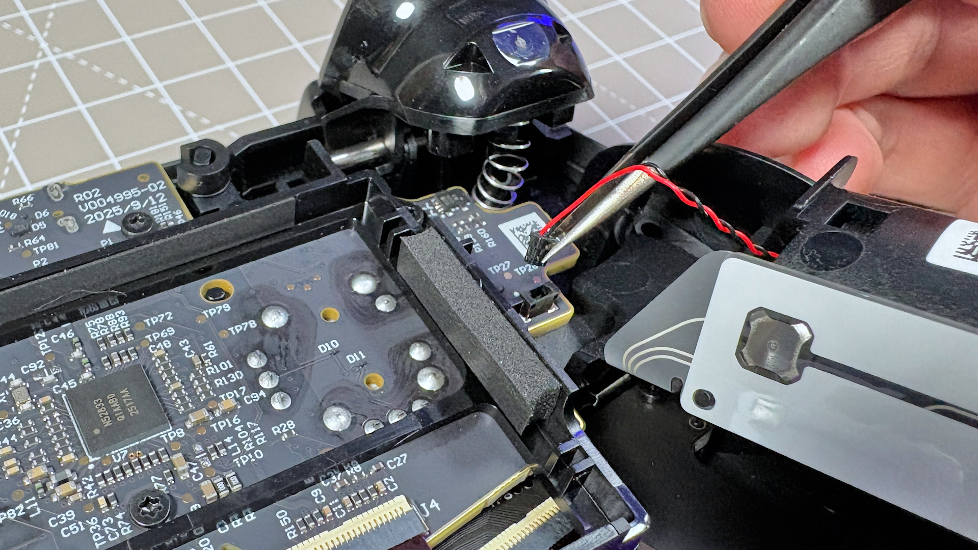 The Steam Controller on a desk during a teardown, with various parts removed.