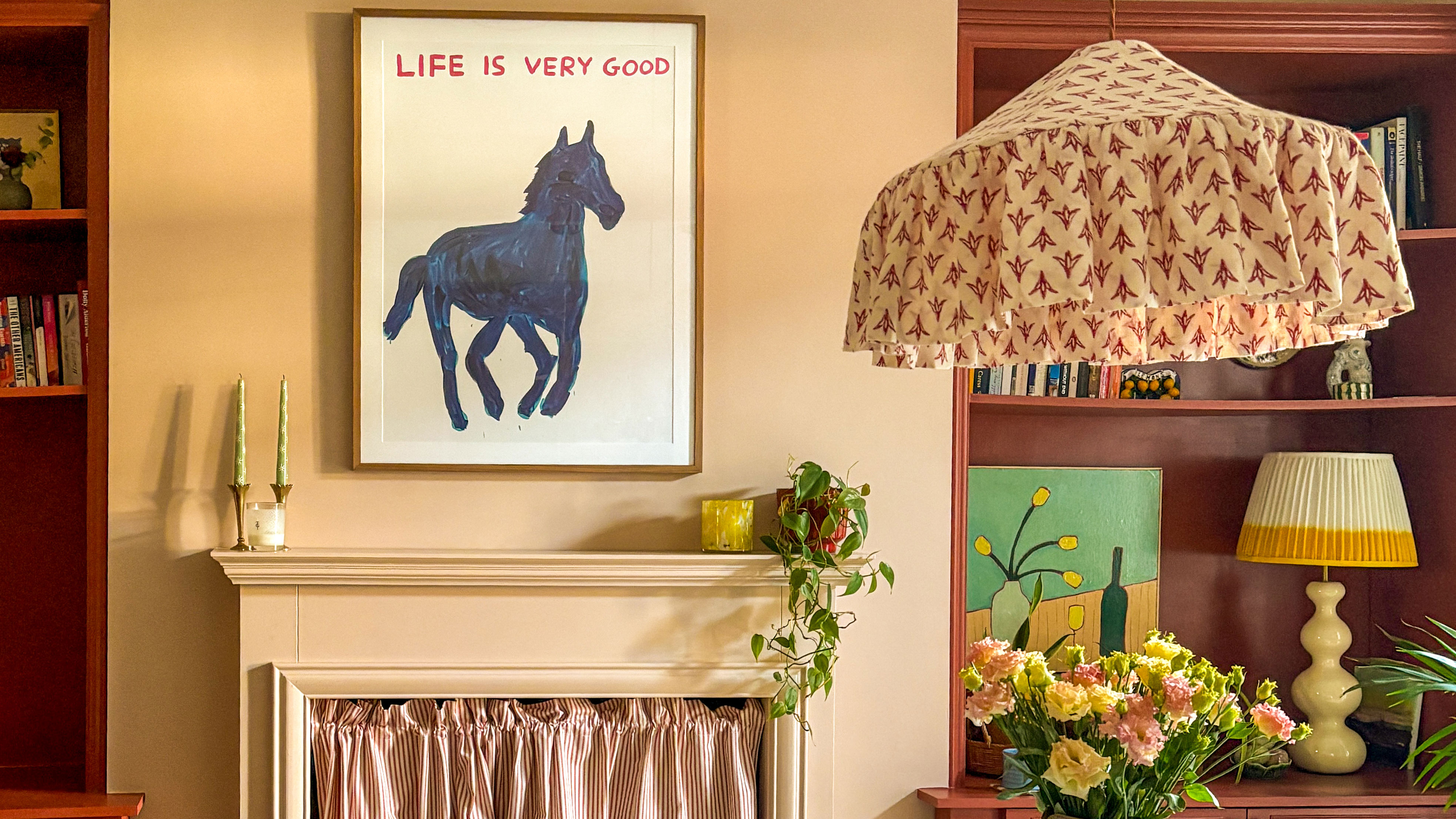 Dining room with oversized fabric lamp shade and horse print above fireplace