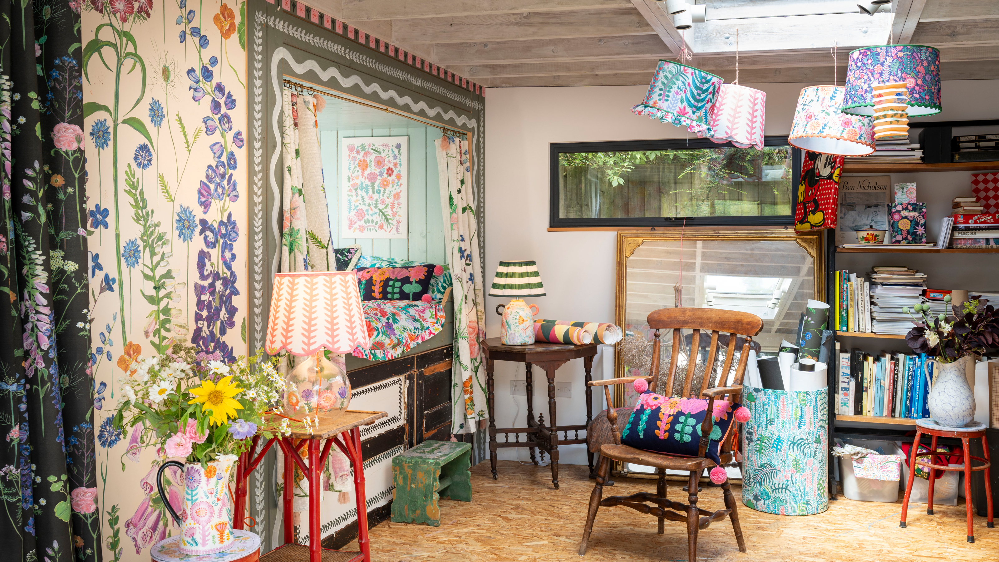 art studio with hand painted walls with a small built-in bed with floral curtains