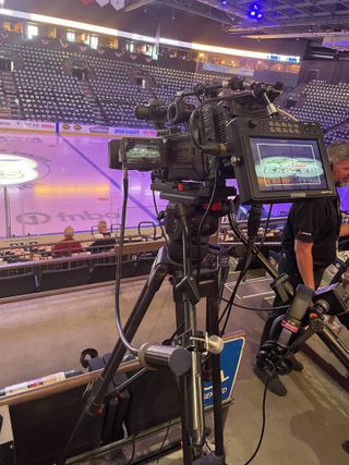 A JVC Professional Video camera, set up at center ice for a hockey game.