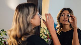 woman using eyelash curler