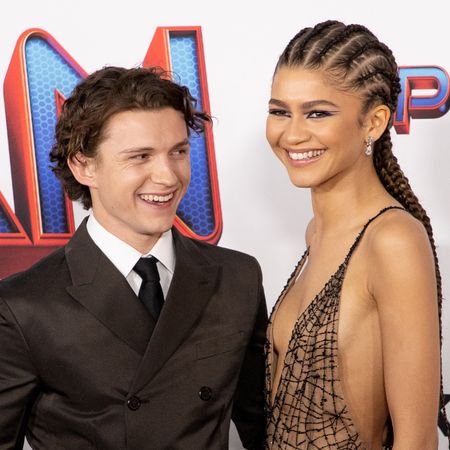 Zendaya and Tom Holland laugh on a red carpet