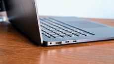 Microsoft Surface Laptop 7 15 on wooden desk, close up showing left hand side ports, including dual USB-C, USB-A and 3.5mm audio. 