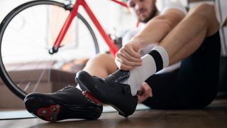 A man putting on shoes for indoor cycling
