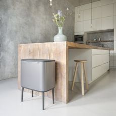 room with white tiled flooring and touch bin