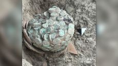 Hoard of copper coins tarnished green and fused together from centuries of corrosion into a single lump that weighs about 12 pounds (5.5 kg).