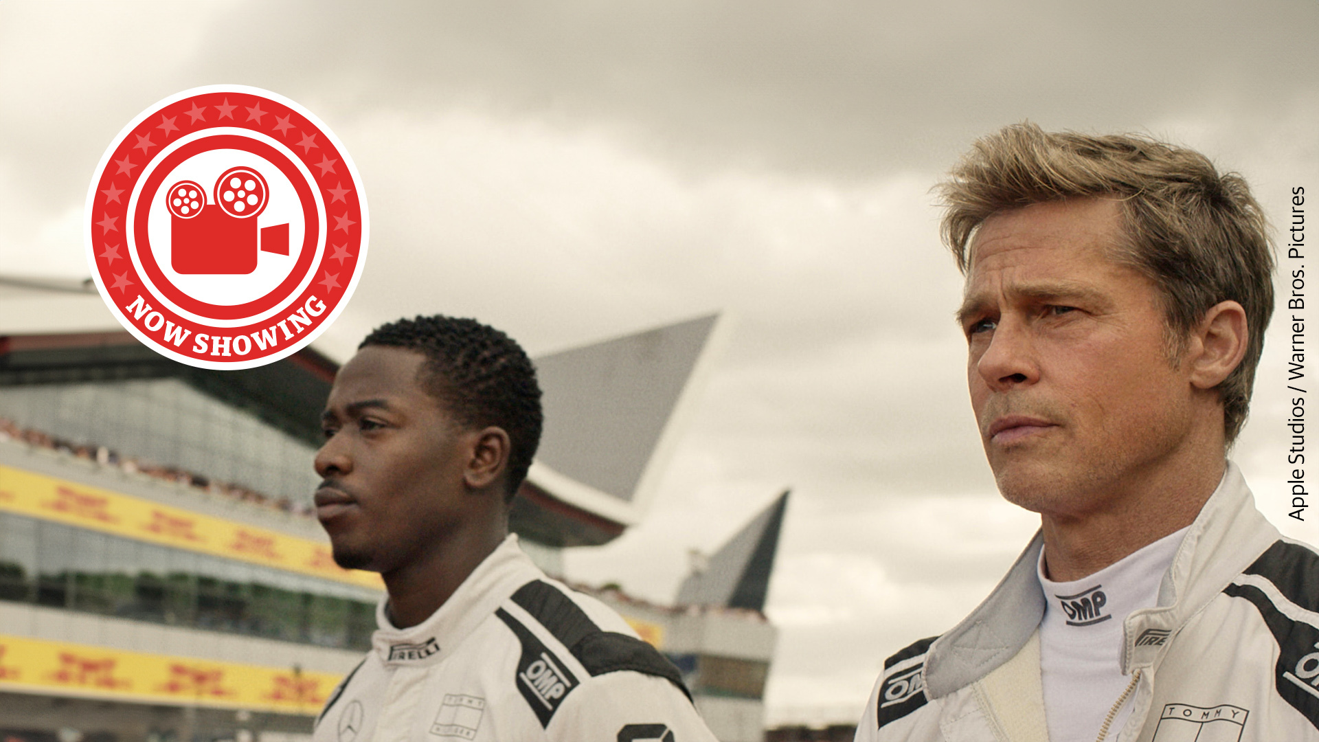 A still from F1 The Movie as two drivers walk towards their vehicles on the racetrack