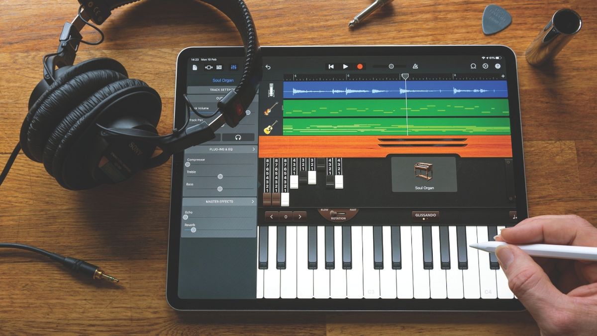 A man uses a stylus on an iPad running GarageBand