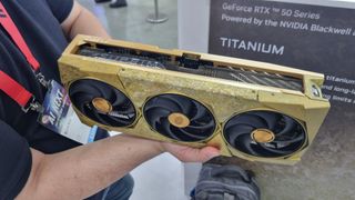 The MSI GeForce RTX 5090 32G Suprim Titanium Edition SOC graphics card being held in the hand at Computex 2025