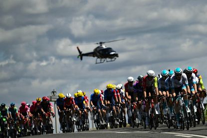 A helicopter hovers over the peloton during the 2025 Tour de France