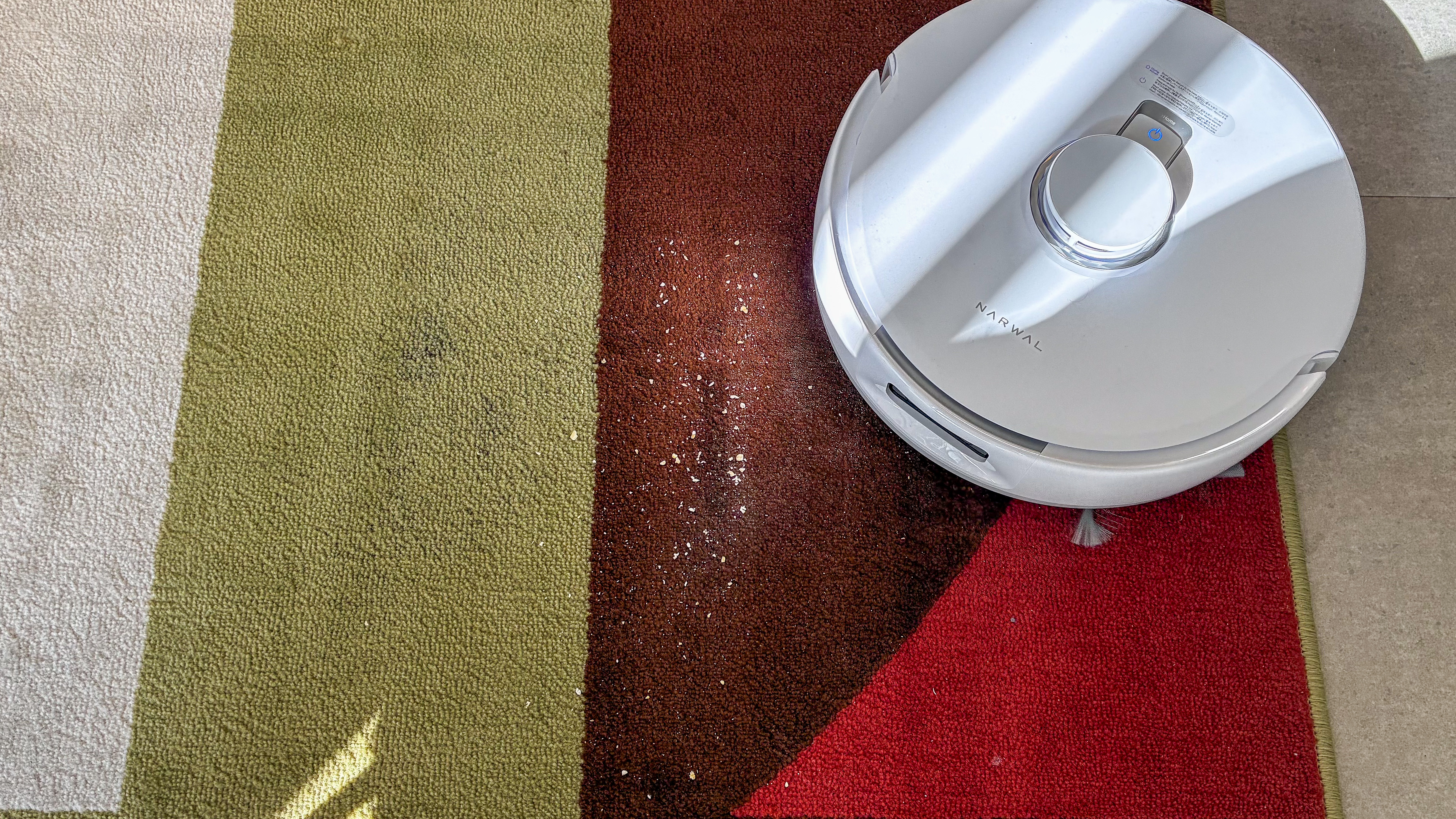 Narwal Freo Z10 vacuuming oats on a colorful rug