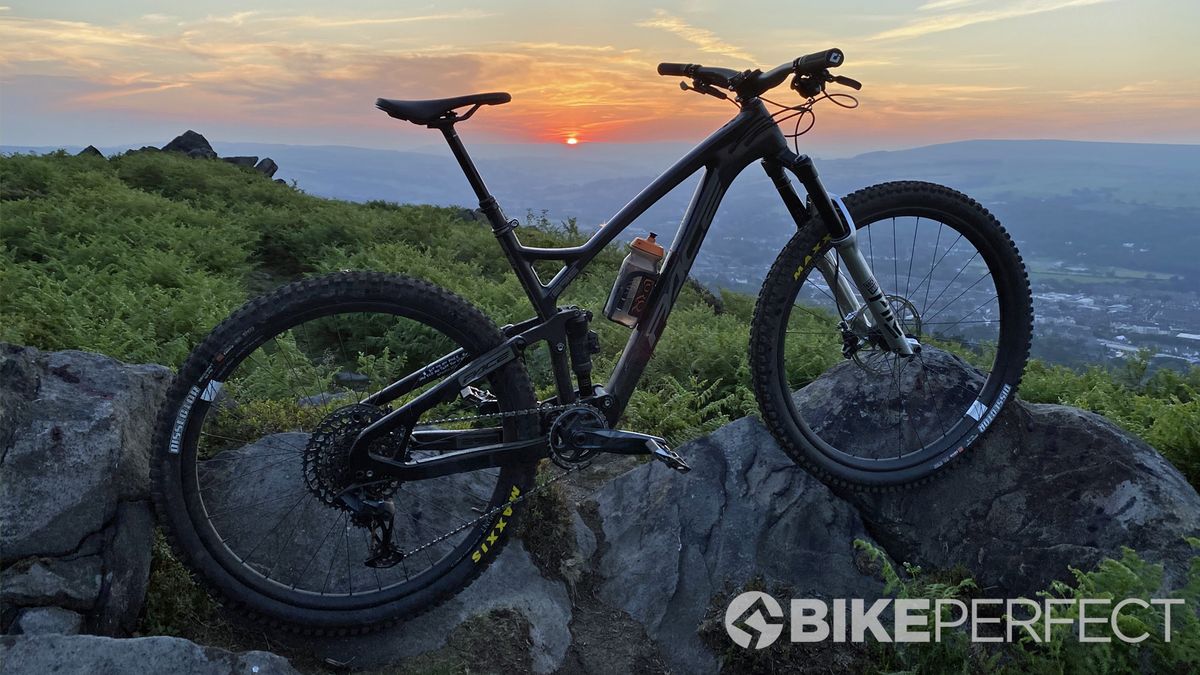 A mountain bike propped up against a sunset landscape