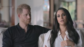 Prince Harry looking at Meghan Markle while she talks to the camera in Harry &amp; Meghan.