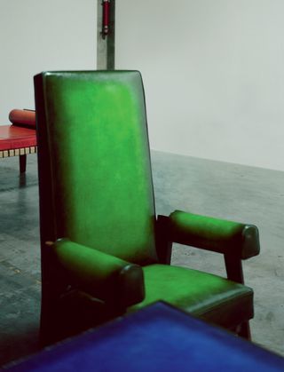 A green armchair is upholstered in Berluti leather