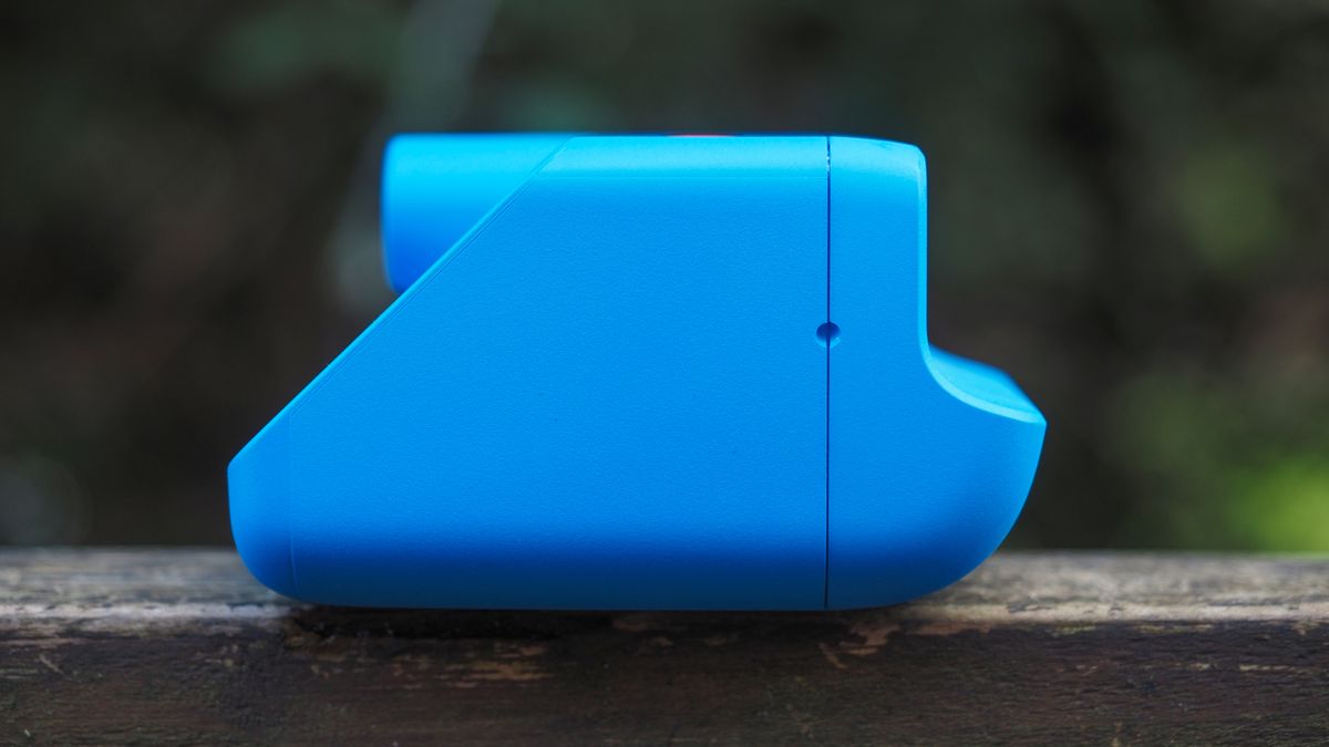 Blue Polaroid Go Gen 2 camera, on a wooden surface in a woodland setting