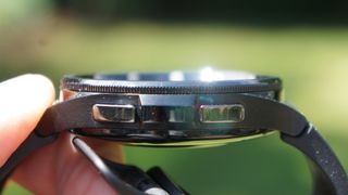 En hand håller upp en svart Samsung Galaxy Watch 6 Classic 47mm och visar upp den från sidan.