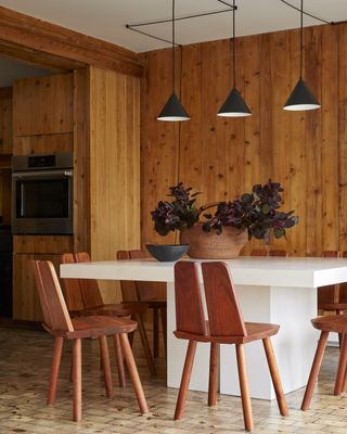dining room with wood panelling walls and pure white dining table and black lights
