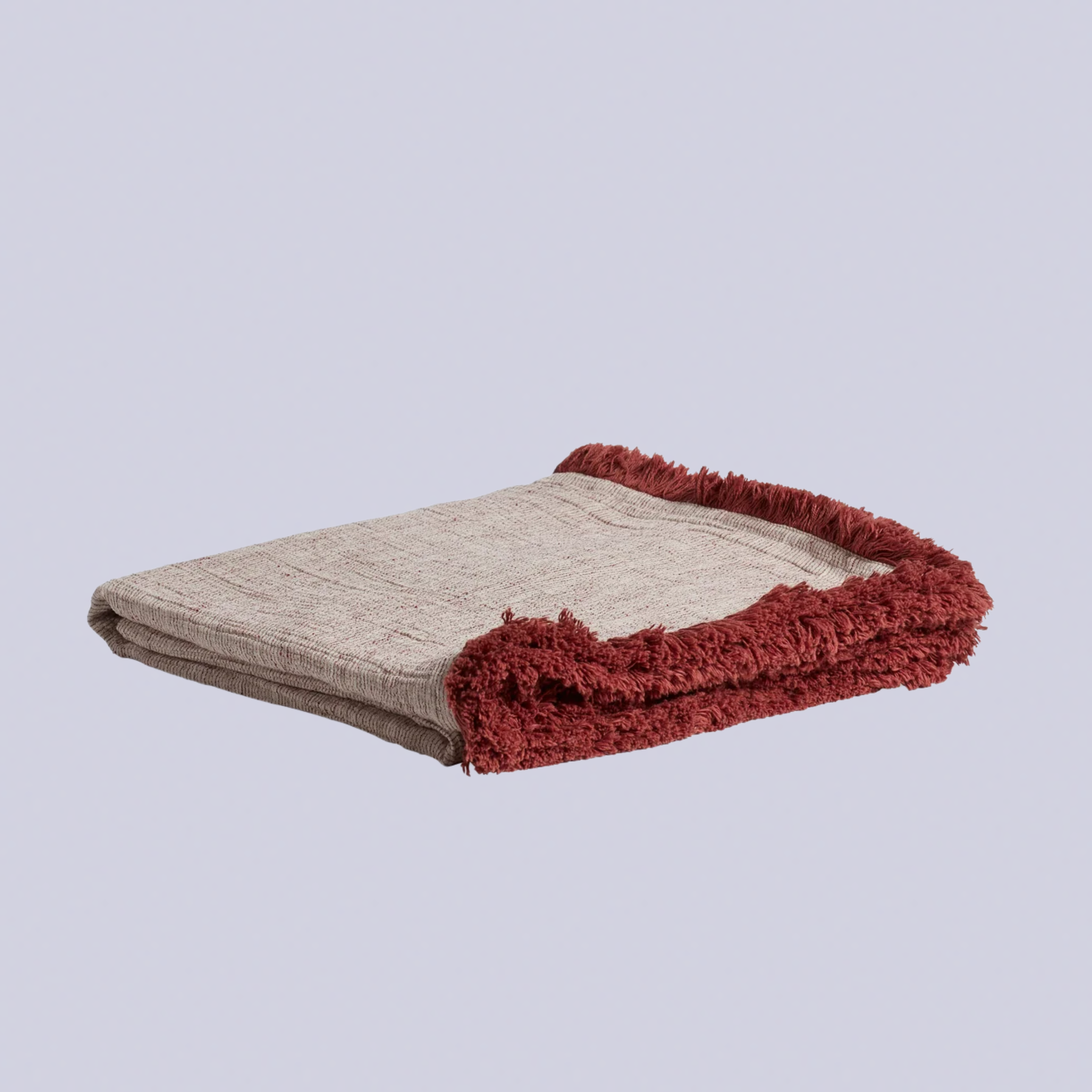 A throw blanket with burgundy fringing