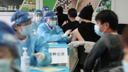 People get their vaccinations at a temporary centre in Beijing, China