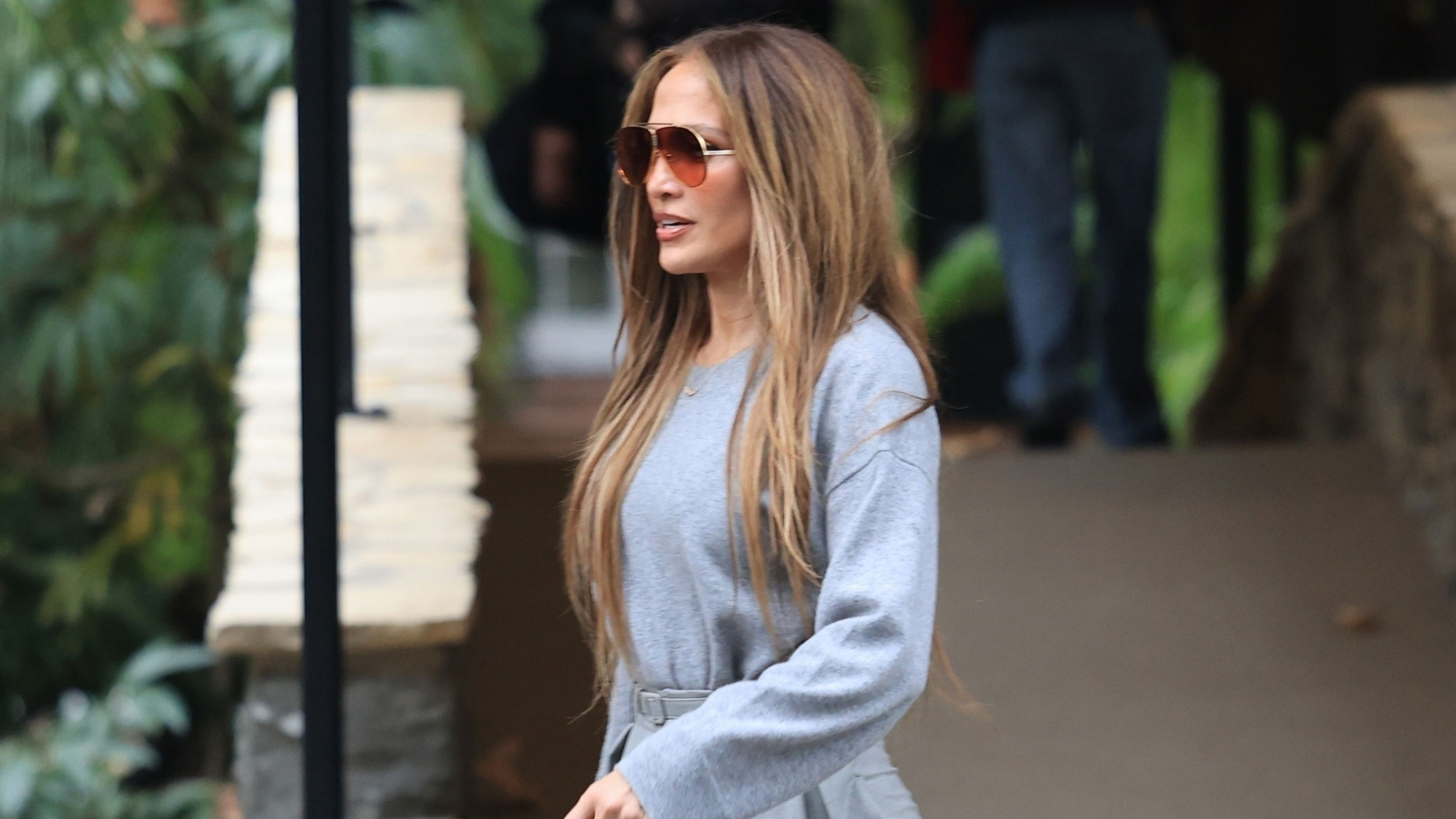 Jennifer Lopez wears gray wide-leg pants with platform heels