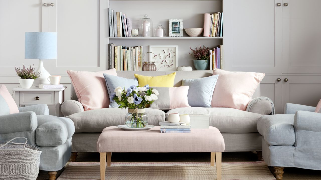 Pastel linen sofa and armchairs around ottoman in living room