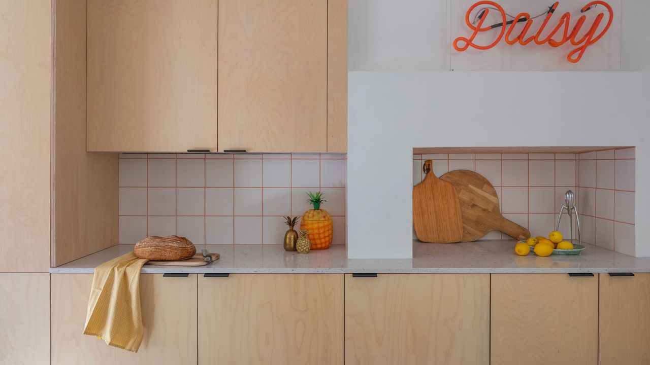 A plywood kitchen with a neon sign