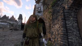 Kingdom Come Deliverance 2 screenshot of Henry standing in front of a blacksmith sign with his dog Mutt