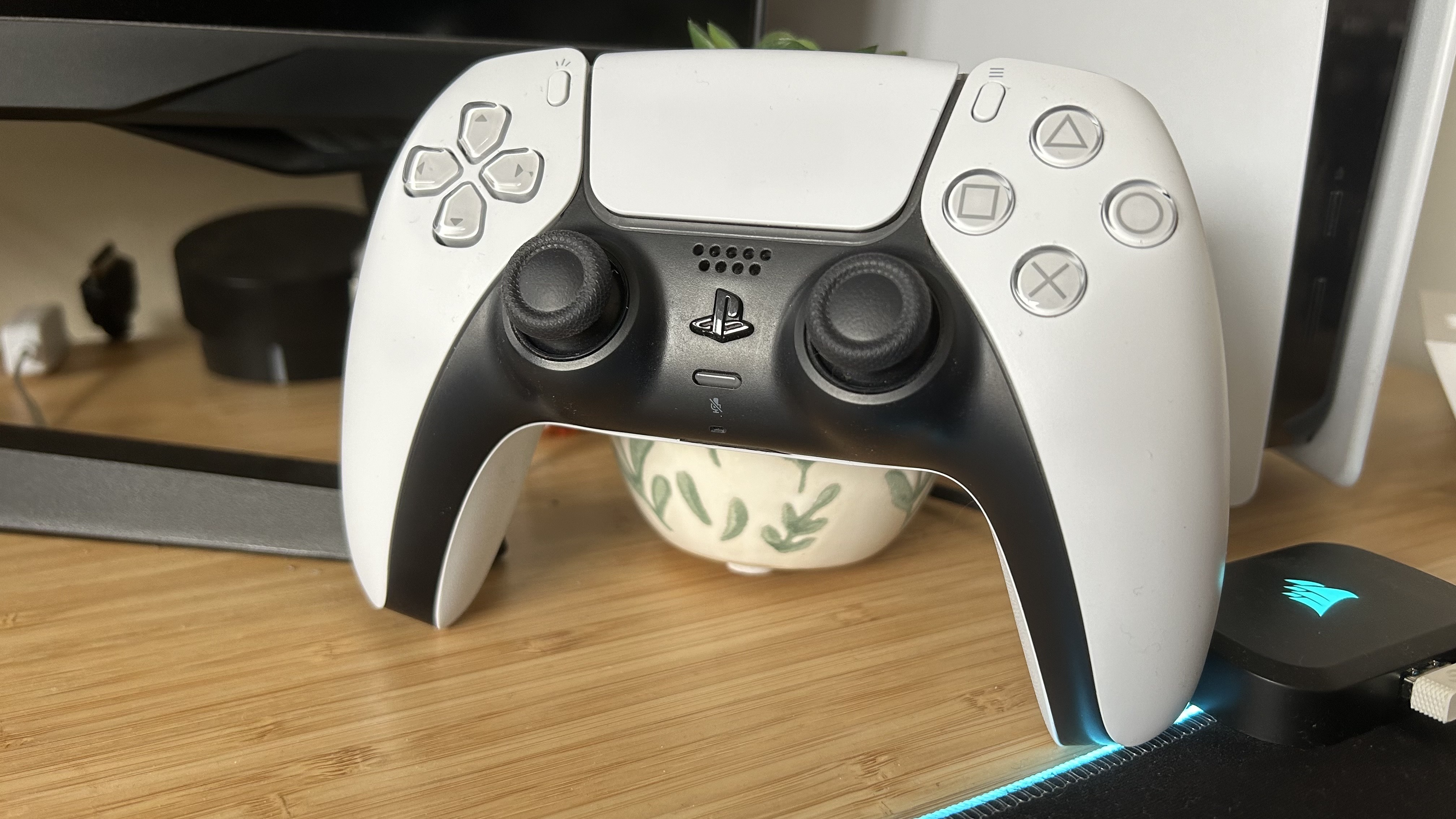 PS5 controller standing on a wooden desk