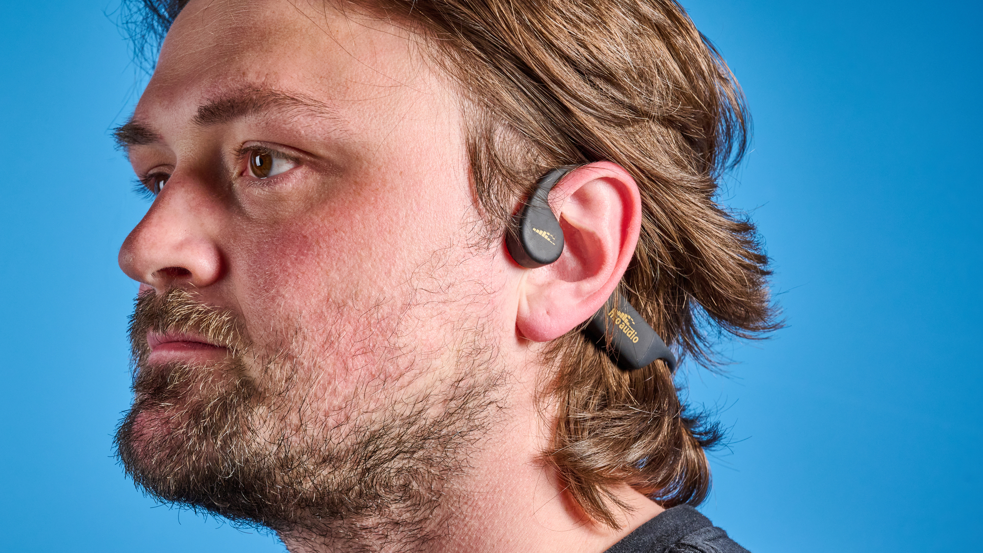 H2O Audio TRI 2 PRO headphones photographed in front of a blue background