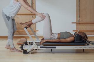 Pilates vs yoga: Sportswoman Doing Pilates Exercise with her Trainer