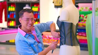 Danny Godoy measuring a piece of clothing on a mannequin