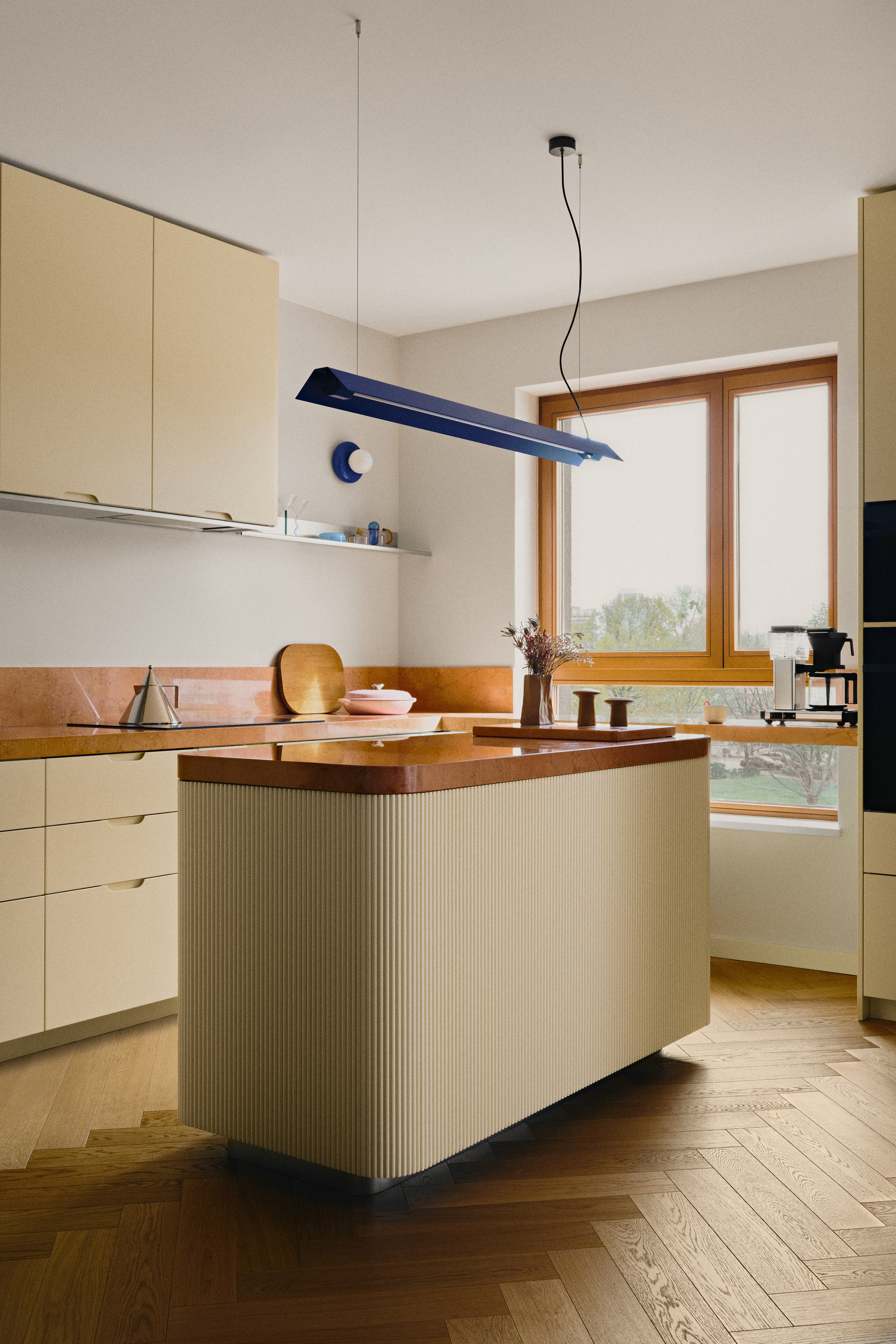 A modern kitchen with wooden herringbone flooring and butter yellow cabinet fronts