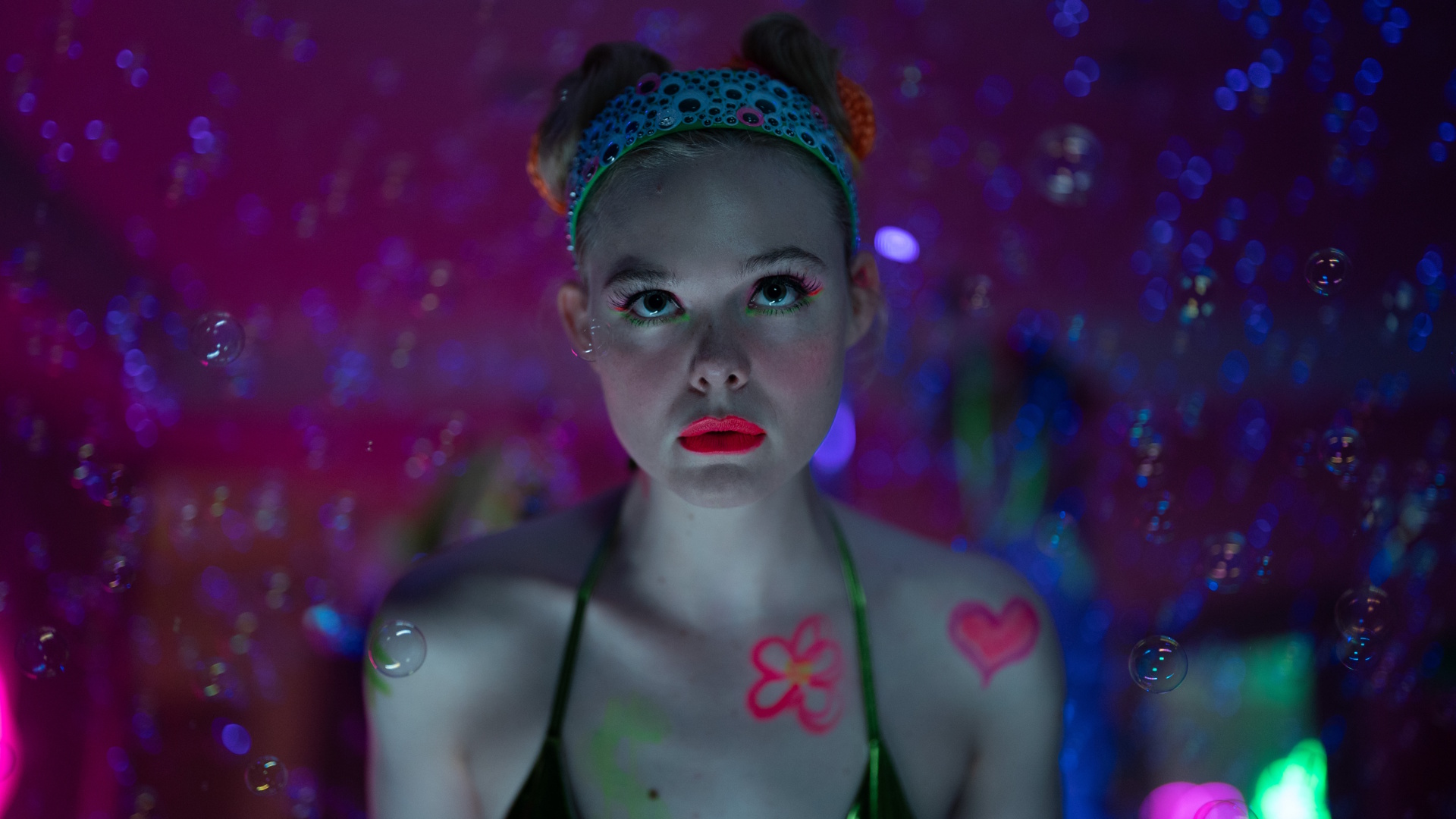A close up of Elle Fanning wearing bright red lipstick in a scene from Apple TV's 'Margo&rsquo;s Got Money Trouble'.