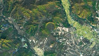 Satellite photo with a horseshoe-shape impact crater at its center