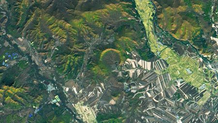 Satellite photo with a horseshoe-shape impact crater at its center