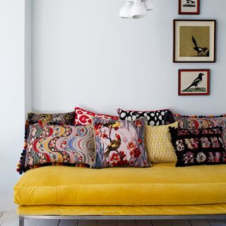 living room with grey wall and yellow sofa with cushions
