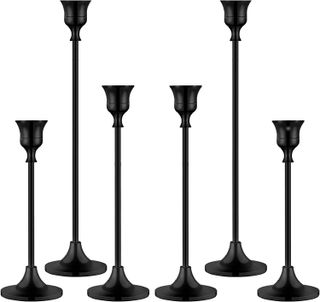 six black candlesticks of different heights