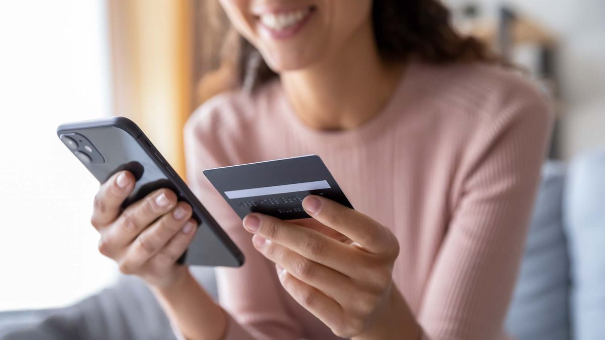 Woman holding phone and credit card in her hands