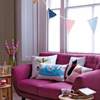 living room with bunding flag on white window and pink sofa