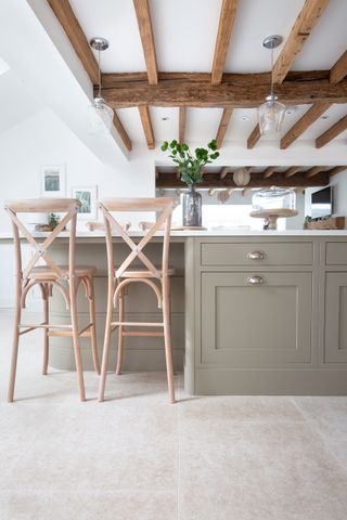 shaker kitchen with exposed wooden beams and stone effect porcelain tiles on floor