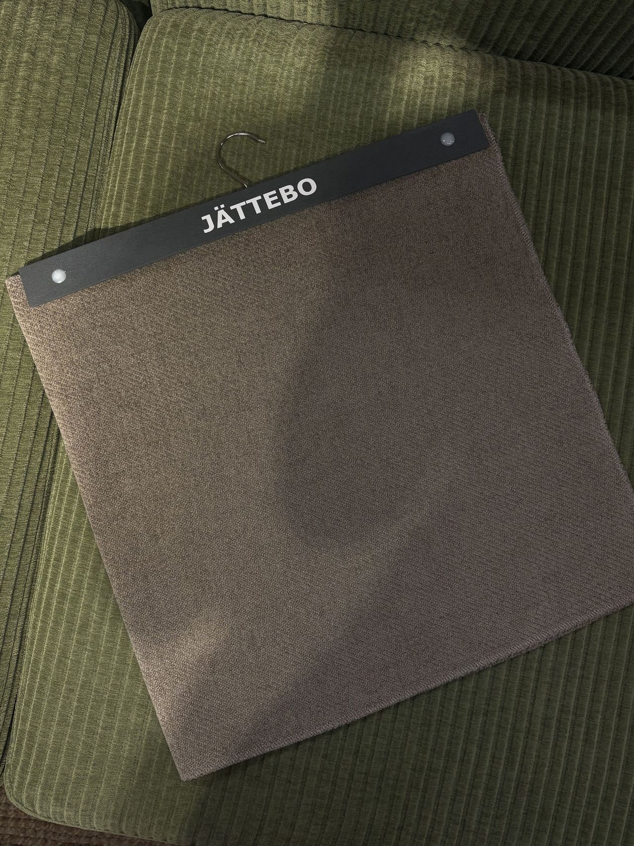 a brown fabric sample on a green couch.