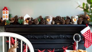 Christmas decorating idea showing pine cones and candle votives dressing a fireplace