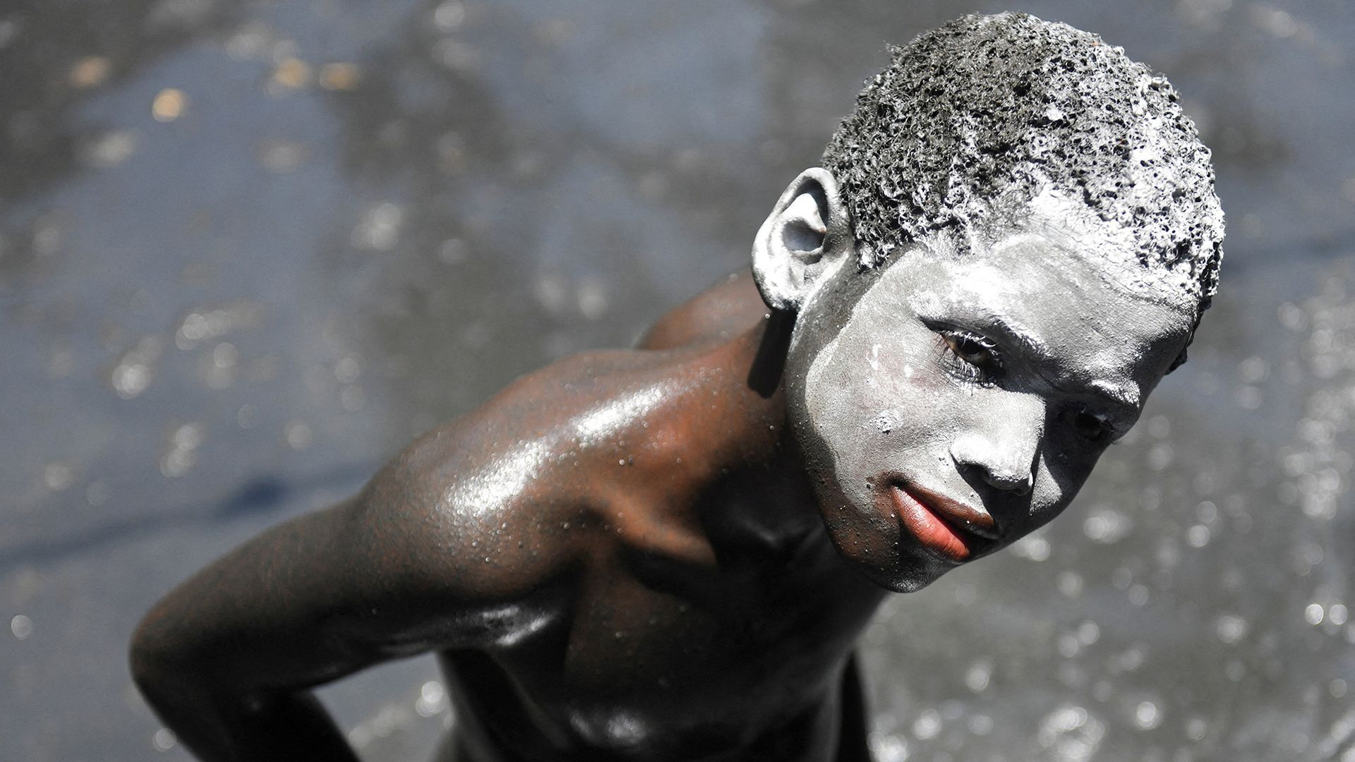
                                A child with his face covered in white kaolin clay takes part in the annual pilgrimage honoring Saint James the Greater, which blends Catholic and Vodou traditions, in Plaine-du-Nord, Haiti
                            