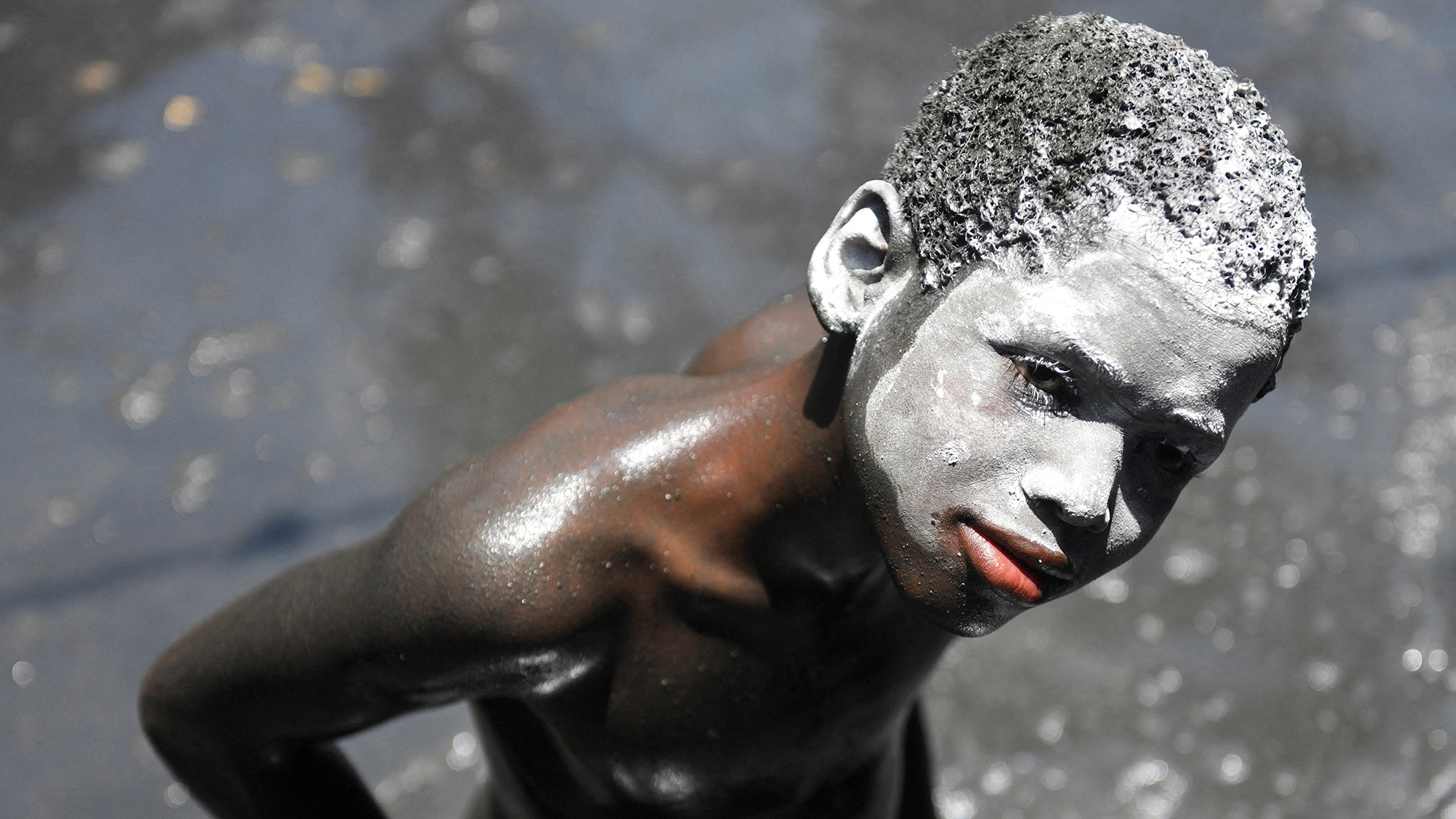 A child with his face covered in white kaolin clay takes part in the annual pilgrimage honoring Saint James the Greater, which blends Catholic and Vodou traditions, in Plaine-du-Nord, Haiti