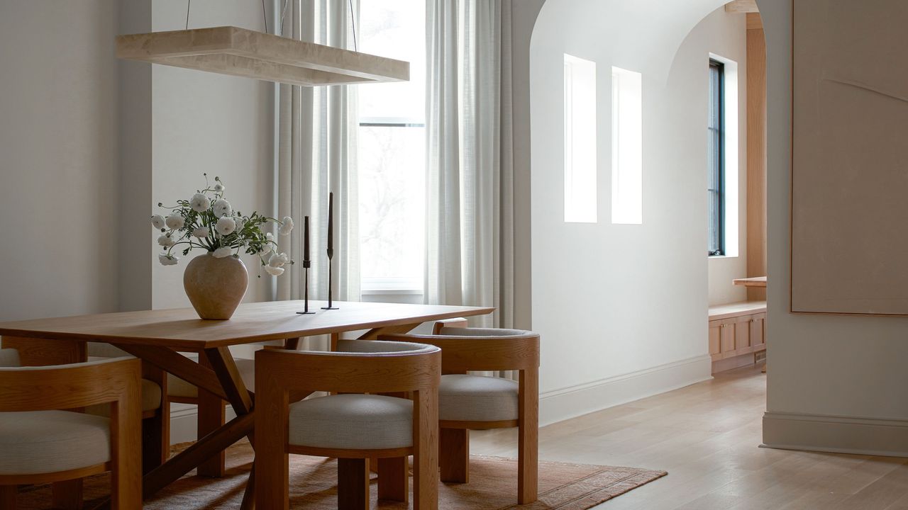 japandi style dining room with timber table, floating pendant light and vase with flowers