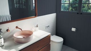 Blue painted bathroom with contemporary pink basin, brass tap and white tiling