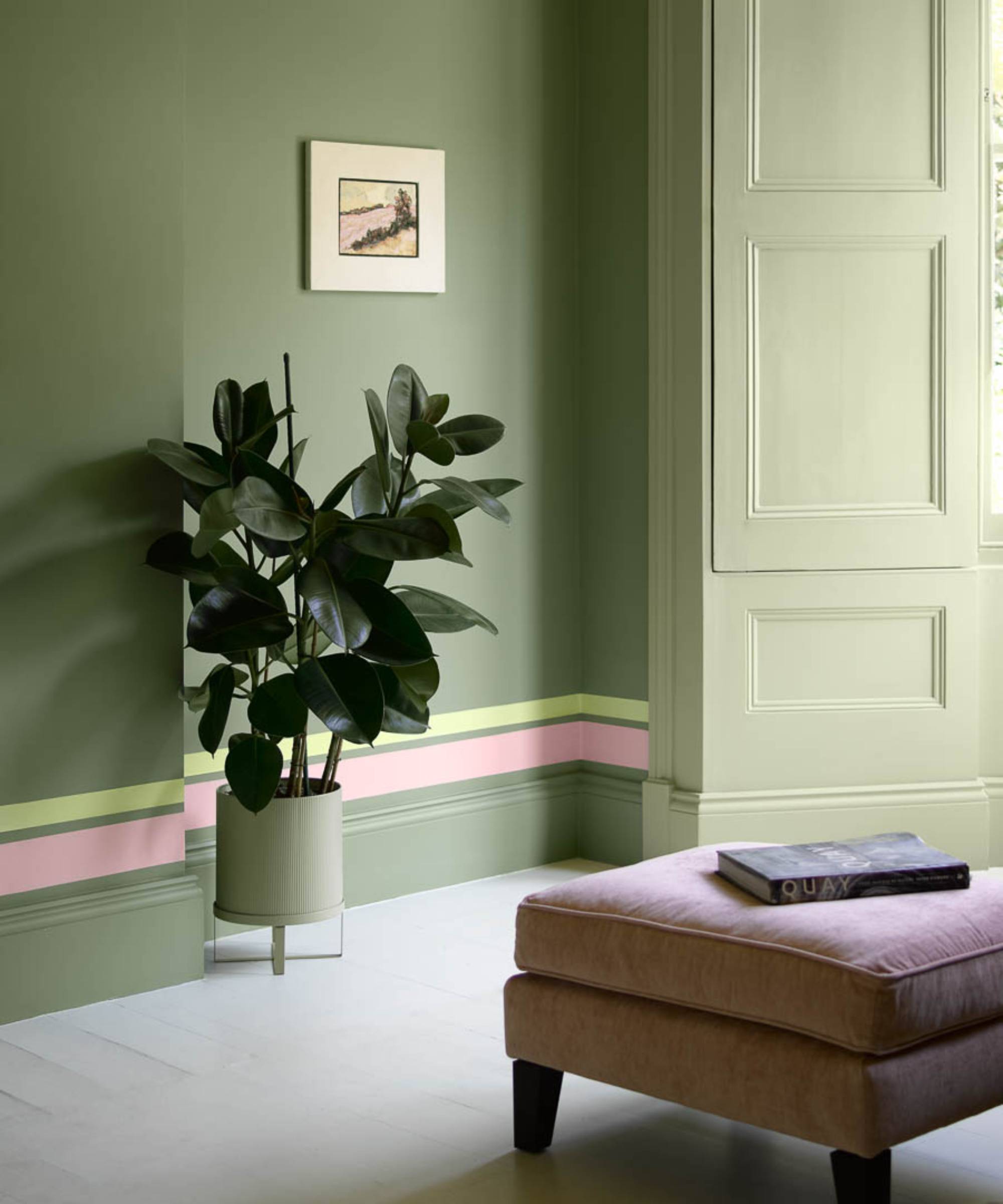 living room colour drenched in green with pink and lime green stripe painted above skirting board