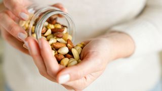 Three foods to reignite your sex life - woman holding handful of assorted nuts