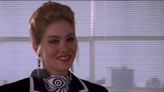 A close up of Christina Applegate smile in business clothes in Don't Tell Mom The Babysitter's Dead