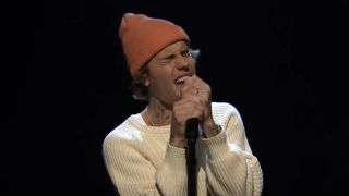 Justin Bieber performing with a beanie on SNL